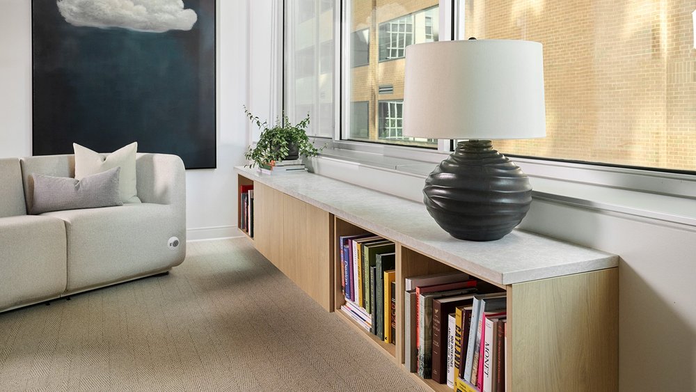 Lounge with oak casework, books and a black ceramic lamp
