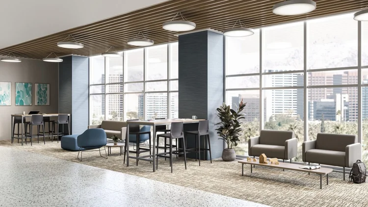 Lounge with blue chairs and high-top tables by city windows