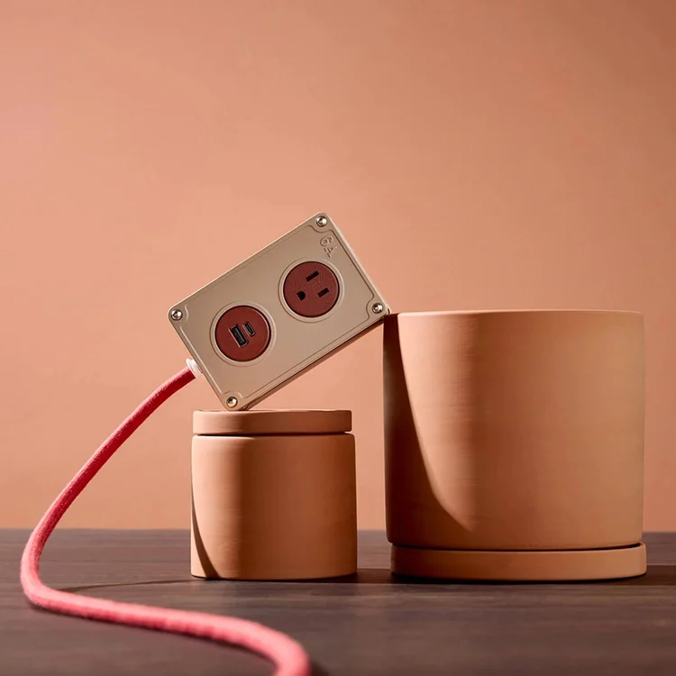 Desktop power and USB unit on a terracotta desk