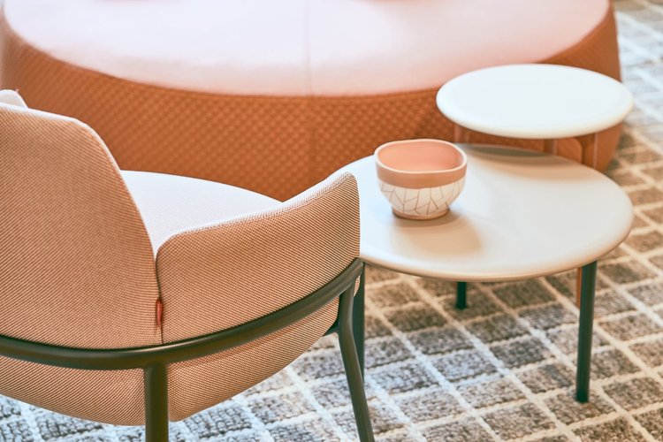 Upholstered lounge chair beside round side tables