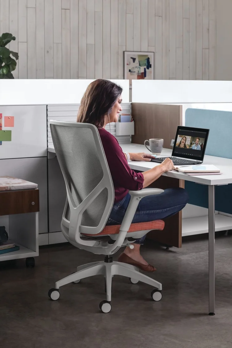 Woman working in a mesh task chair at her desk