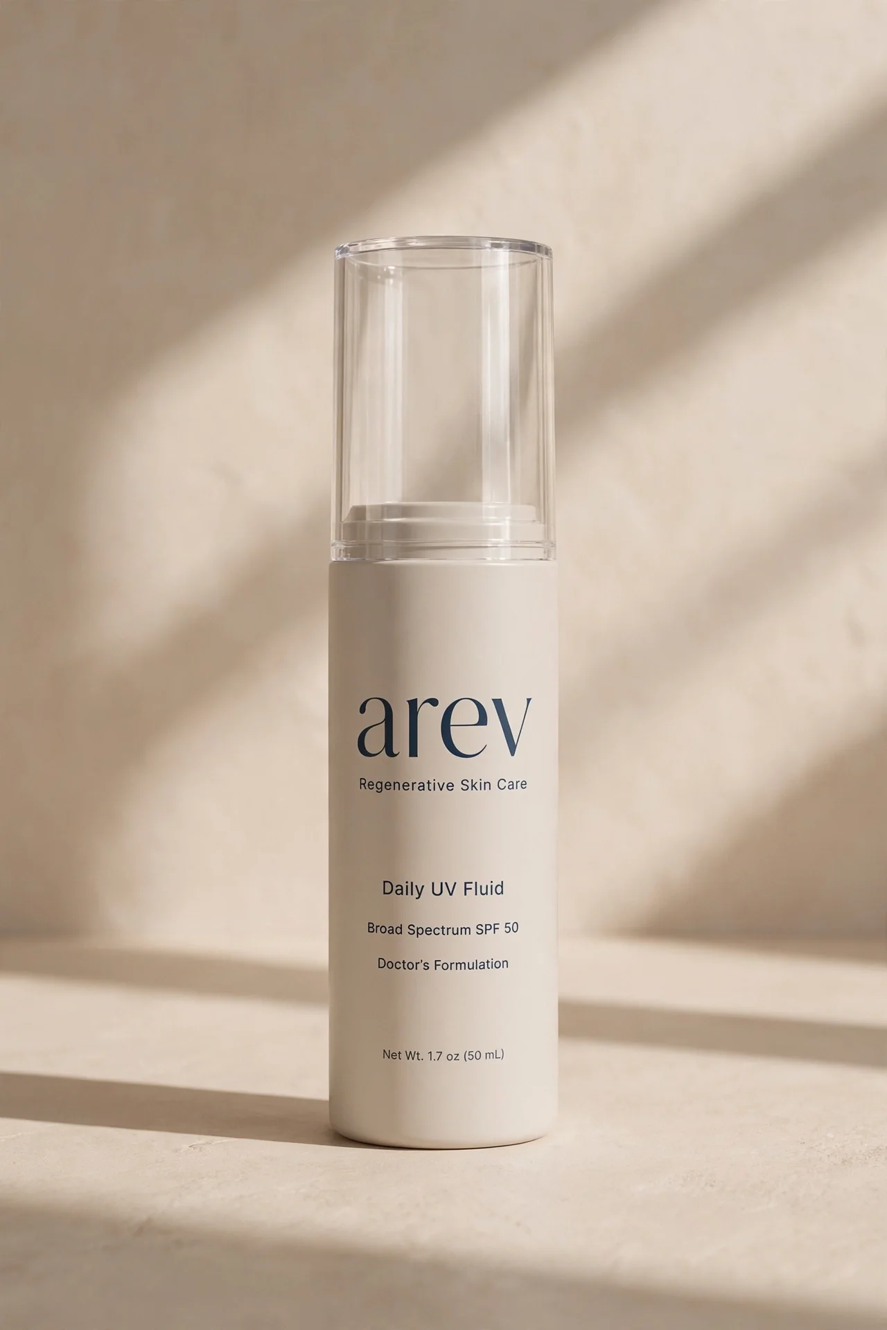 arev Daily UV Fluid airless pump bottle in soft greige, studio portrait