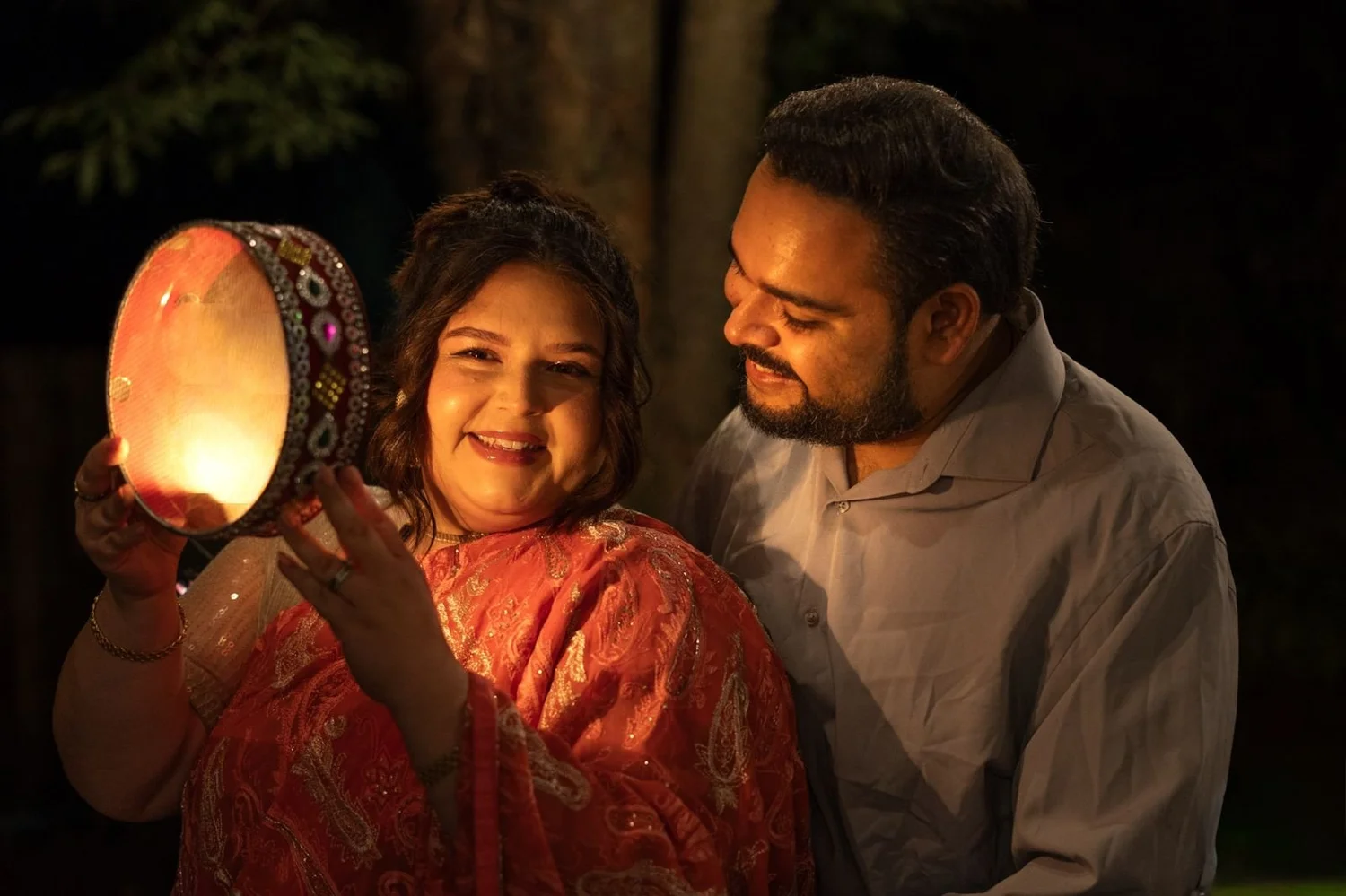 Anastasia and Reeshi at Karwa Chauth, lit by a glowing sieve