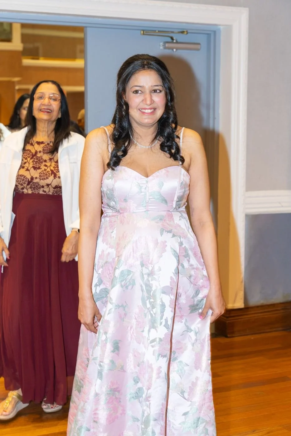 A mother-to-be making her entrance in a floral gown