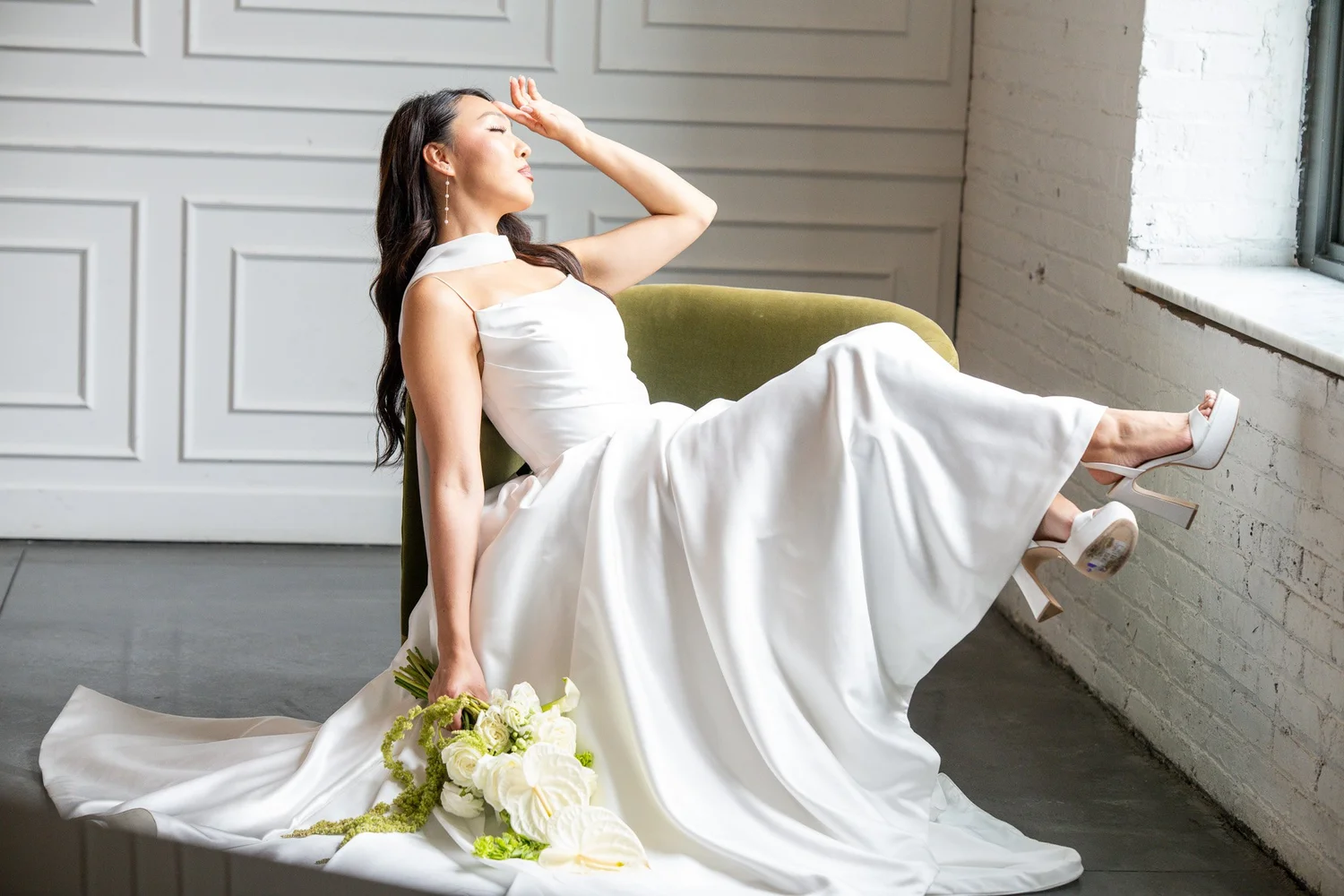 Bride lounging by a sunlit loft window