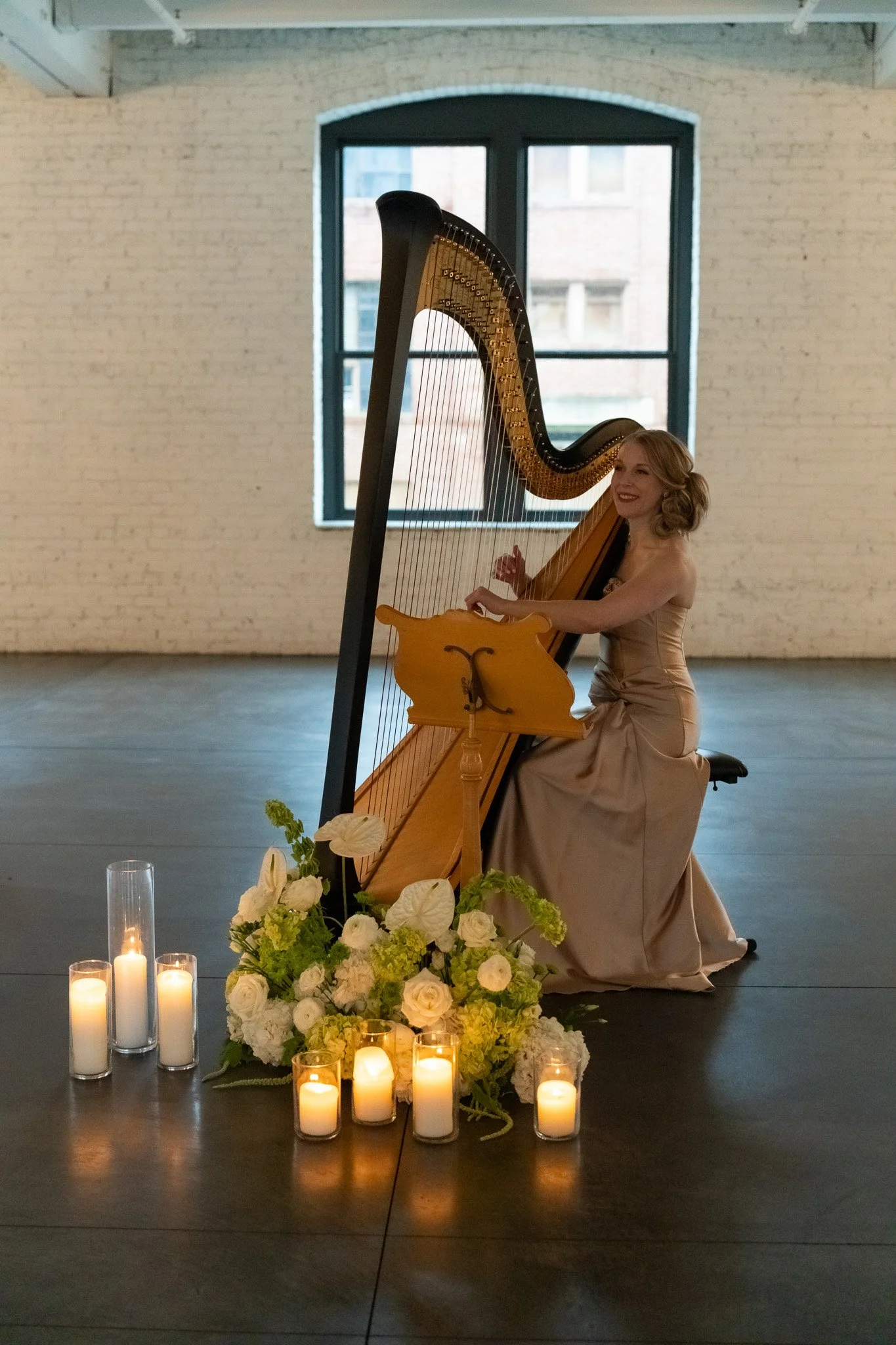 Harpist playing among candles