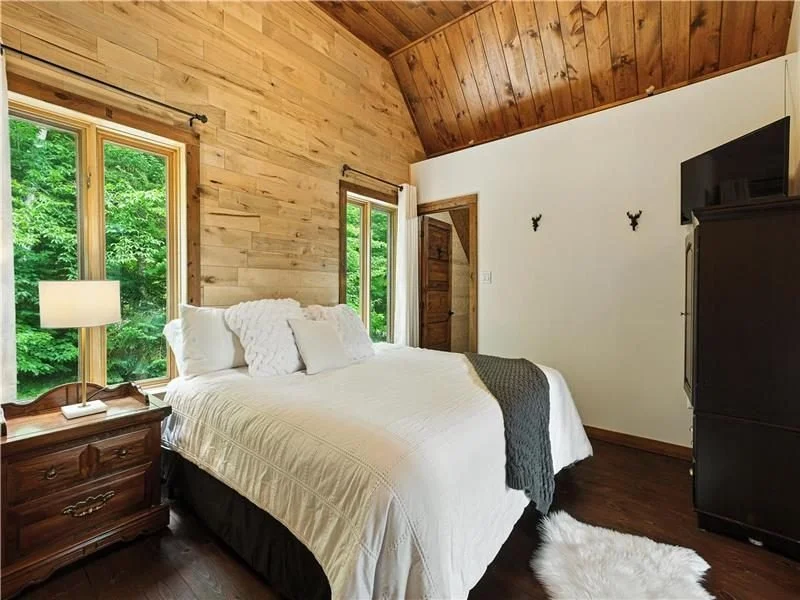 Chambre lumineuse avec grand lit et murs en bois