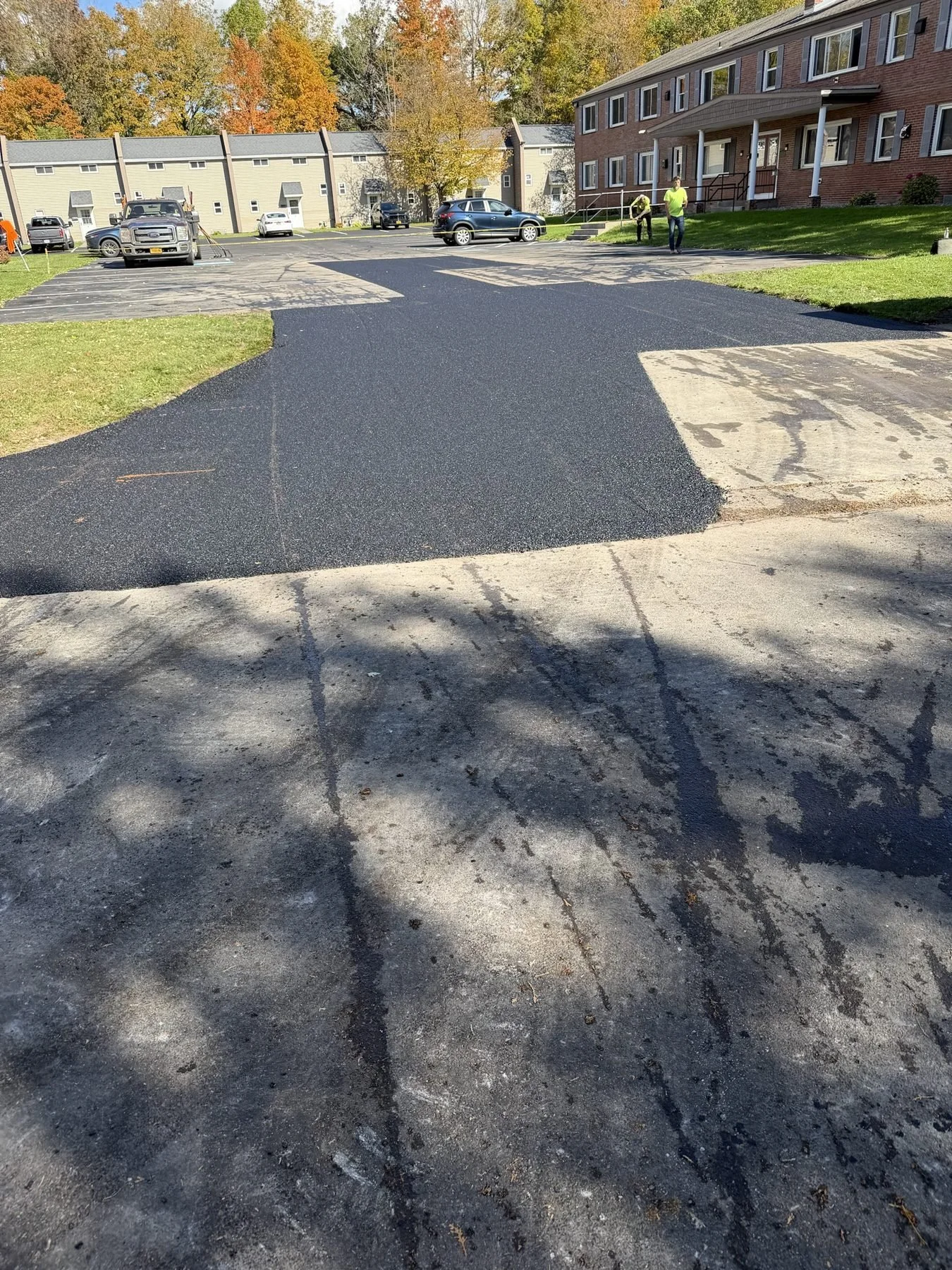 Wide asphalt repair through a parking lot entrance