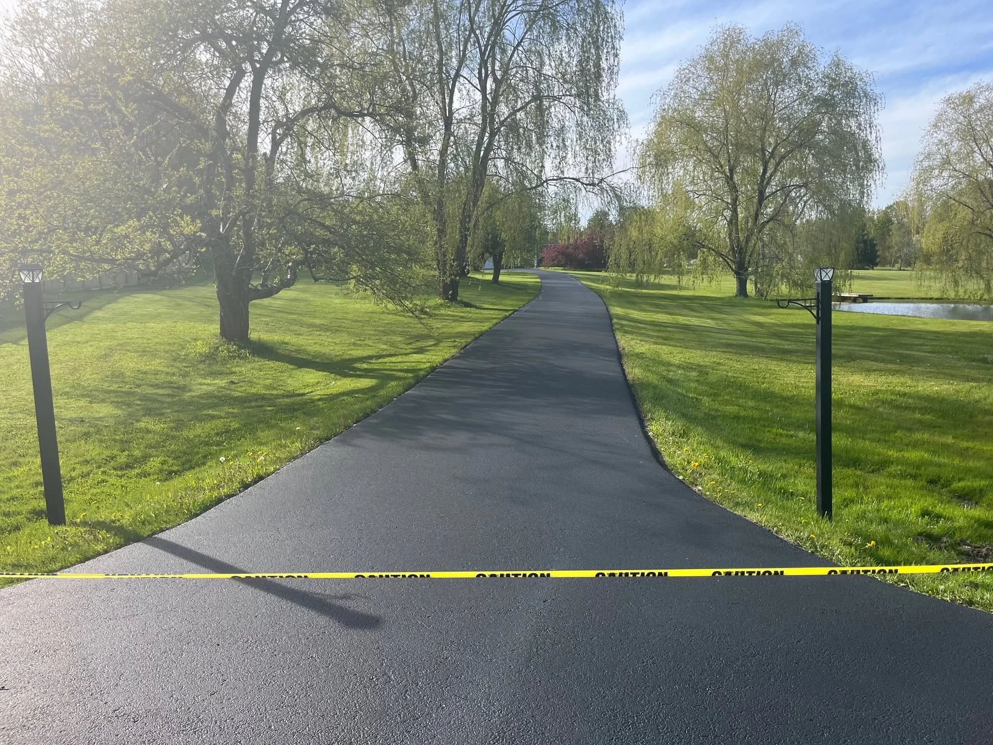 Long tree-lined driveway after sealcoating