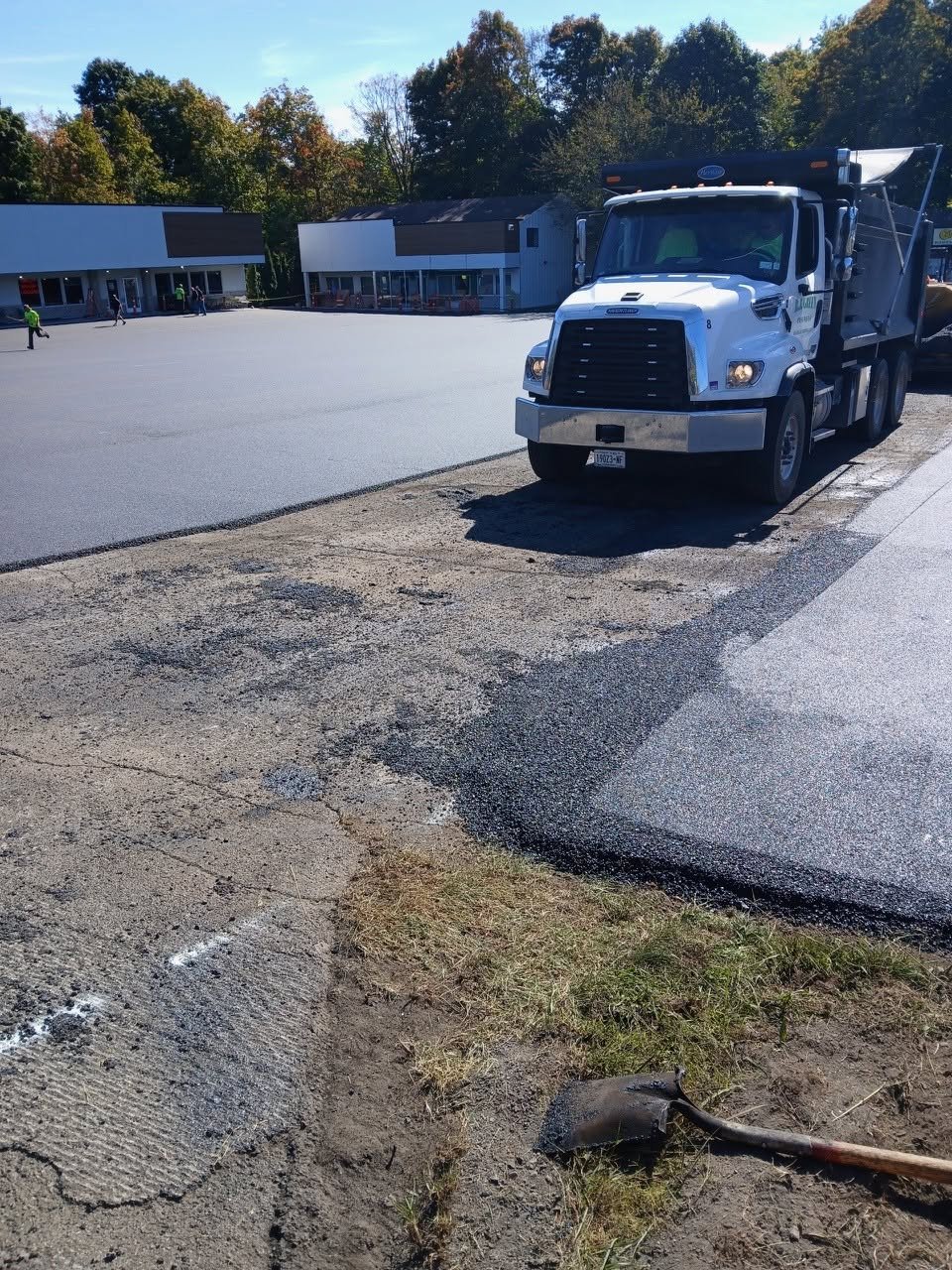 RJ Green dump truck at a commercial plaza paving job