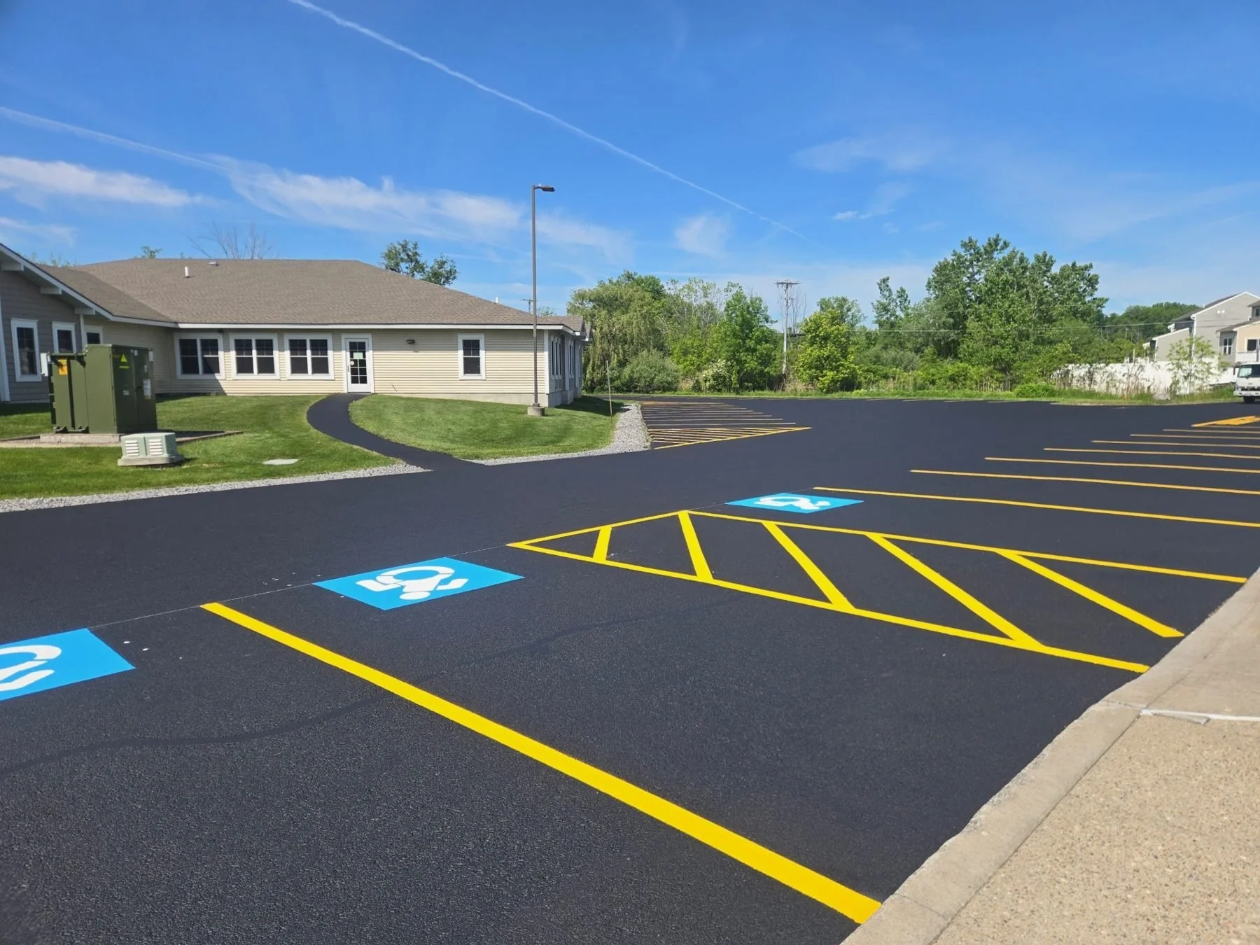 Sealcoated parking lot with fresh yellow lines and accessible spaces