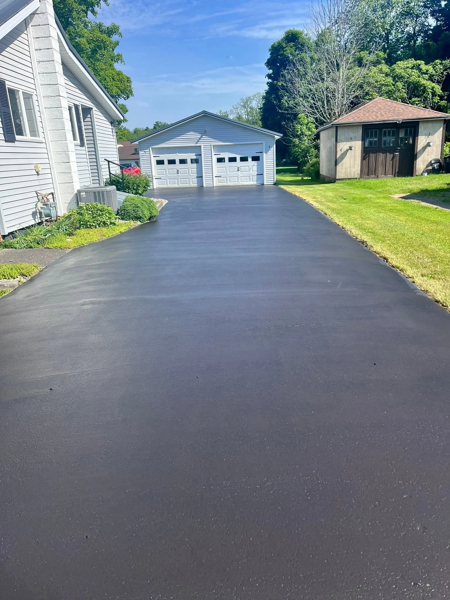 Sealcoated driveway leading to a two-car garage