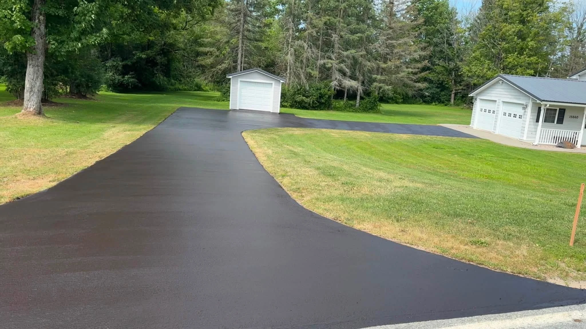 Freshly sealcoated driveway leading to a garage
