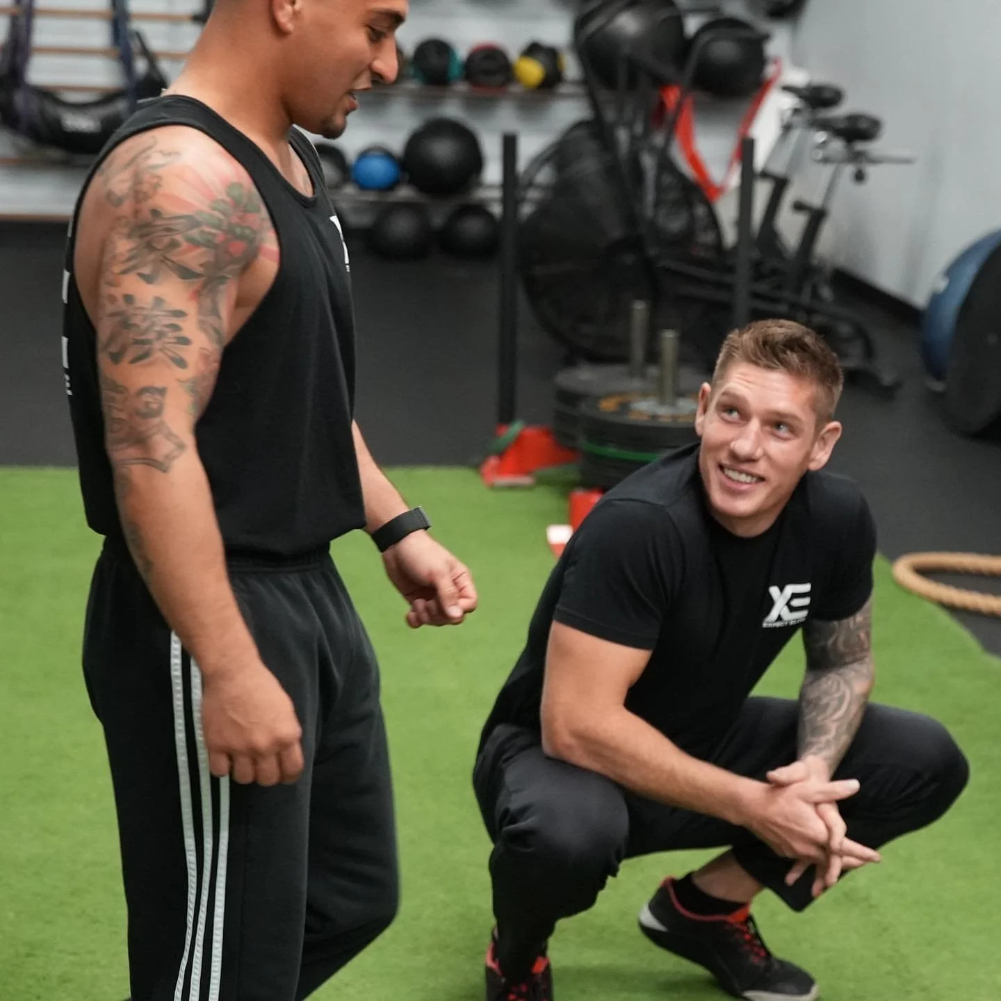Daniel coaching an athlete on the gym turf