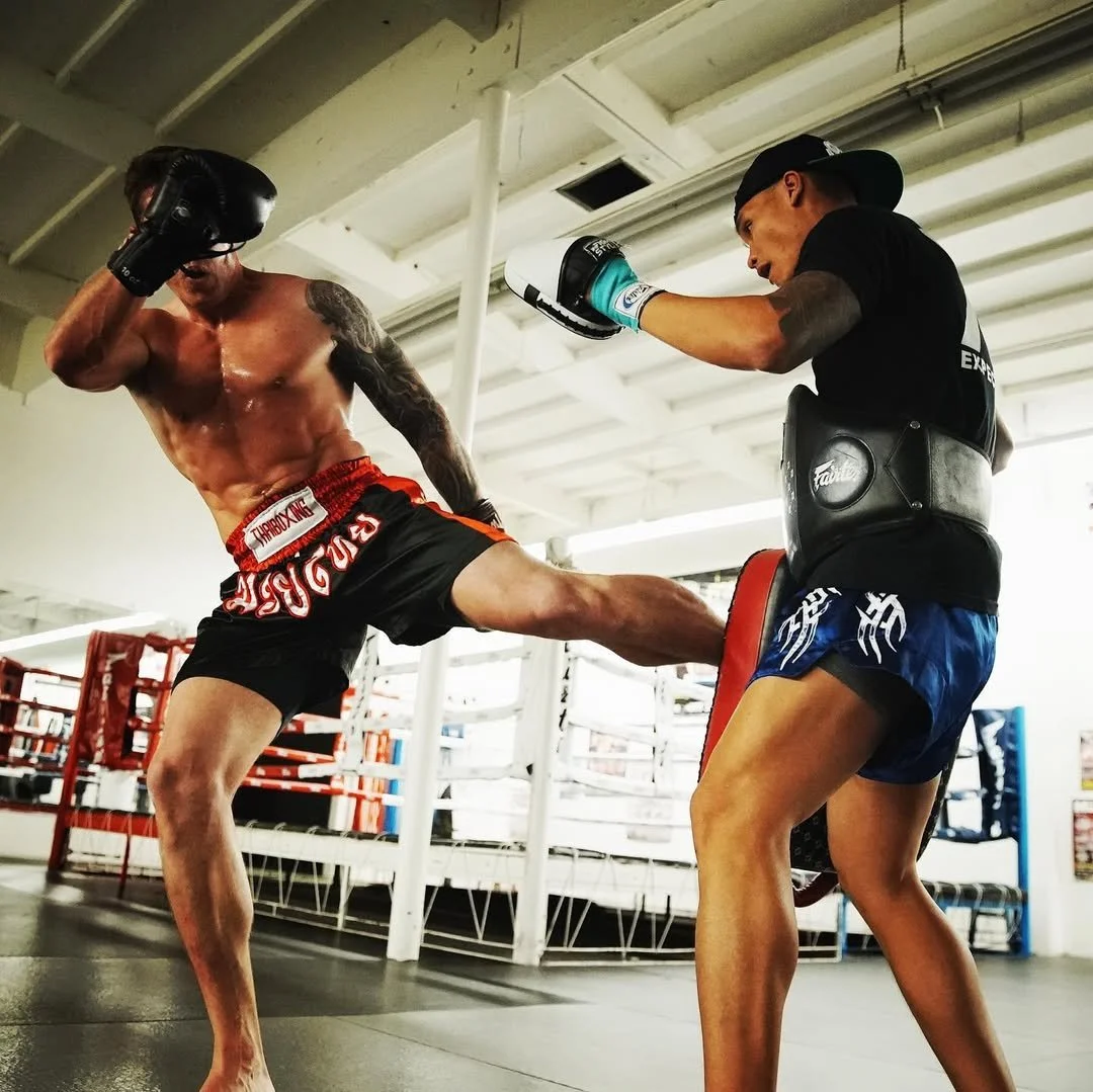 Daniel practicing a kick with his pad holder