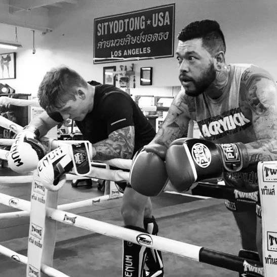 Daniel and a training partner resting on the ring ropes