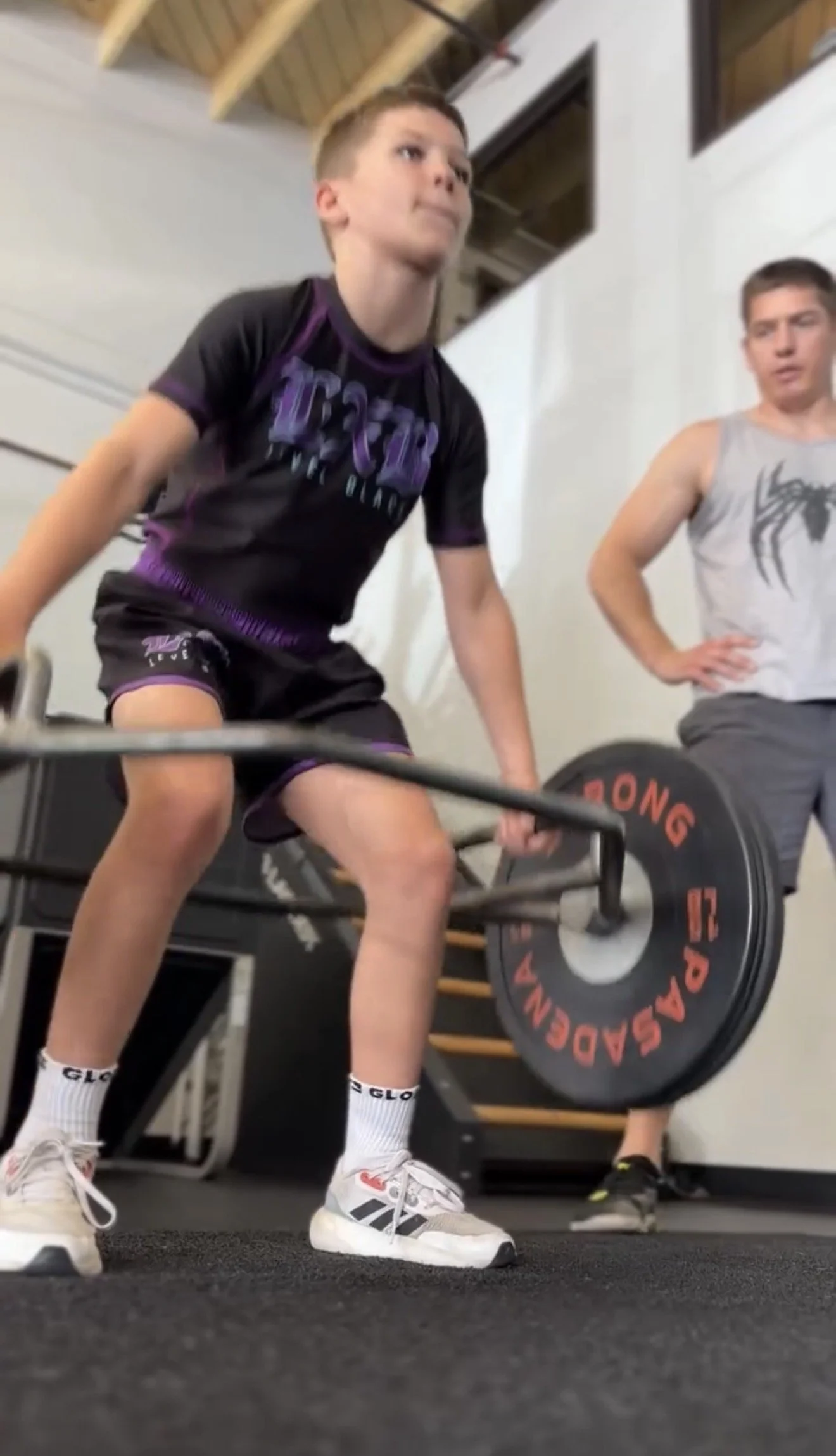 Daniel coaching a young athlete during a trap-bar deadlift