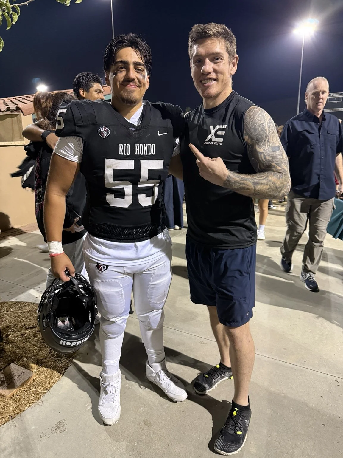 Daniel with a football player after a game