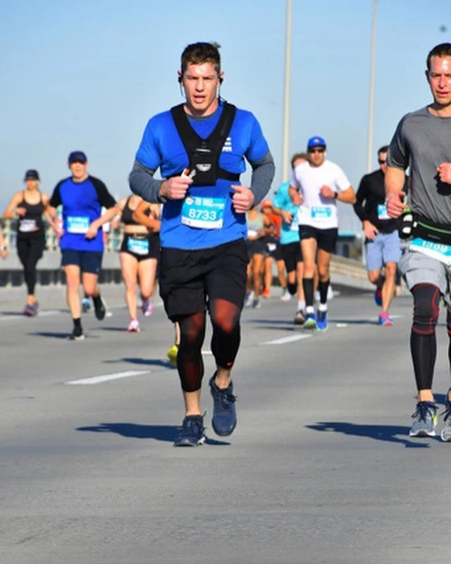 Daniel running a road race wearing a weighted vest