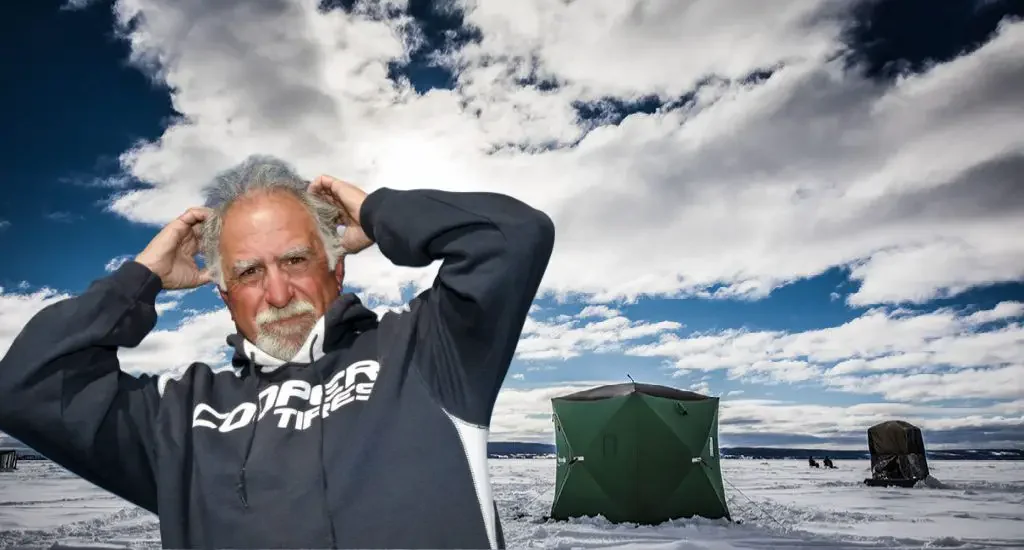 a frustrated angler standing in front of an ice hut