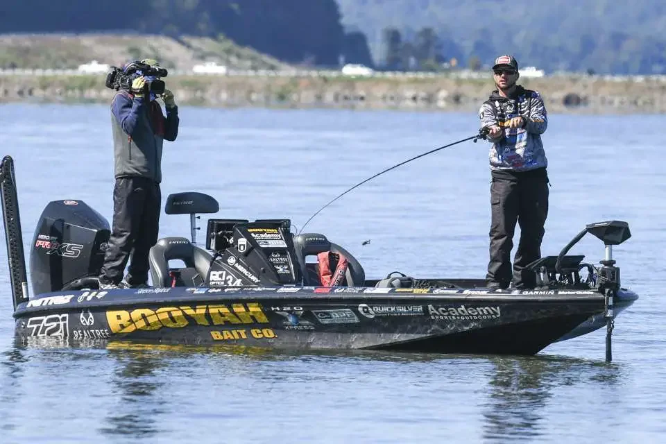 A bass angler casting from a bass boat