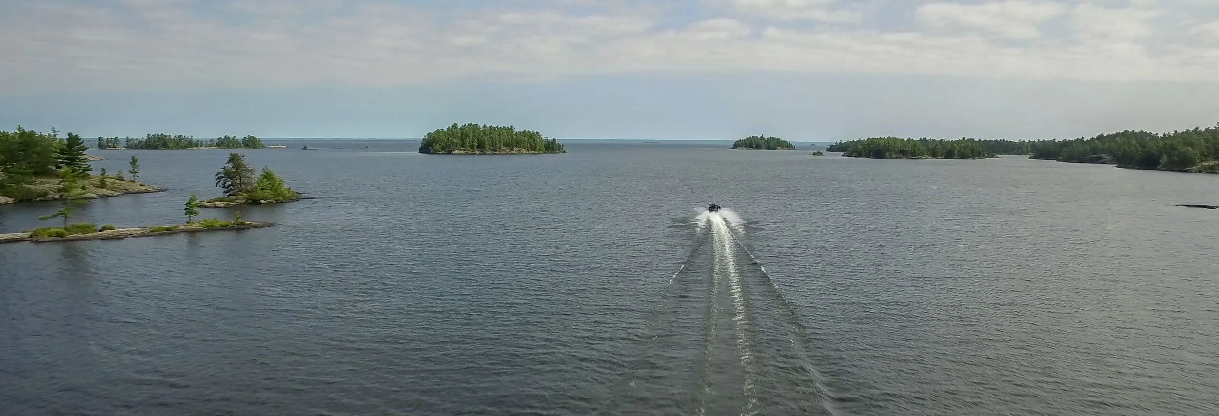 Fishing boat heading through lake islands