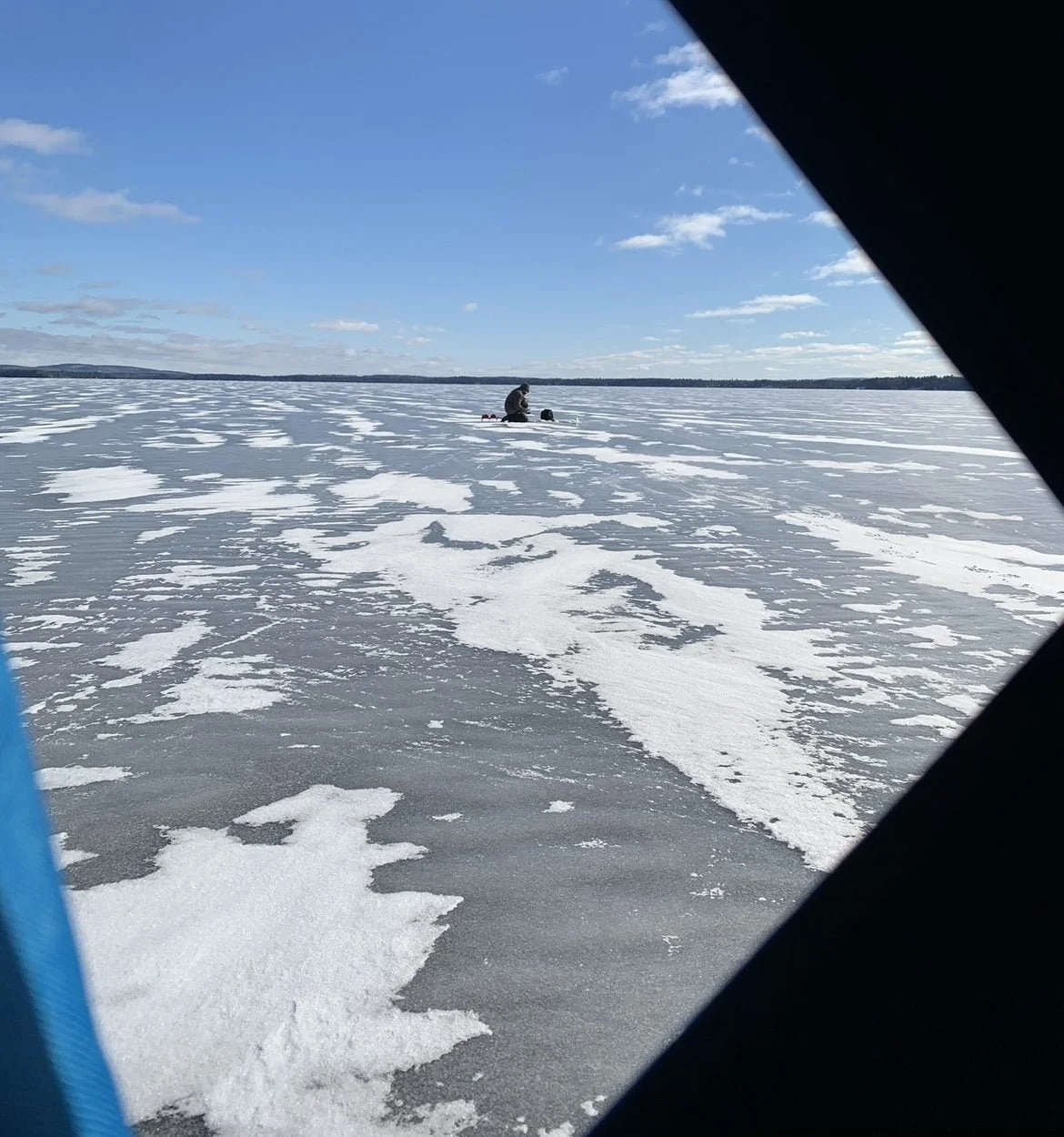 An angler ice fishing for midday walleye