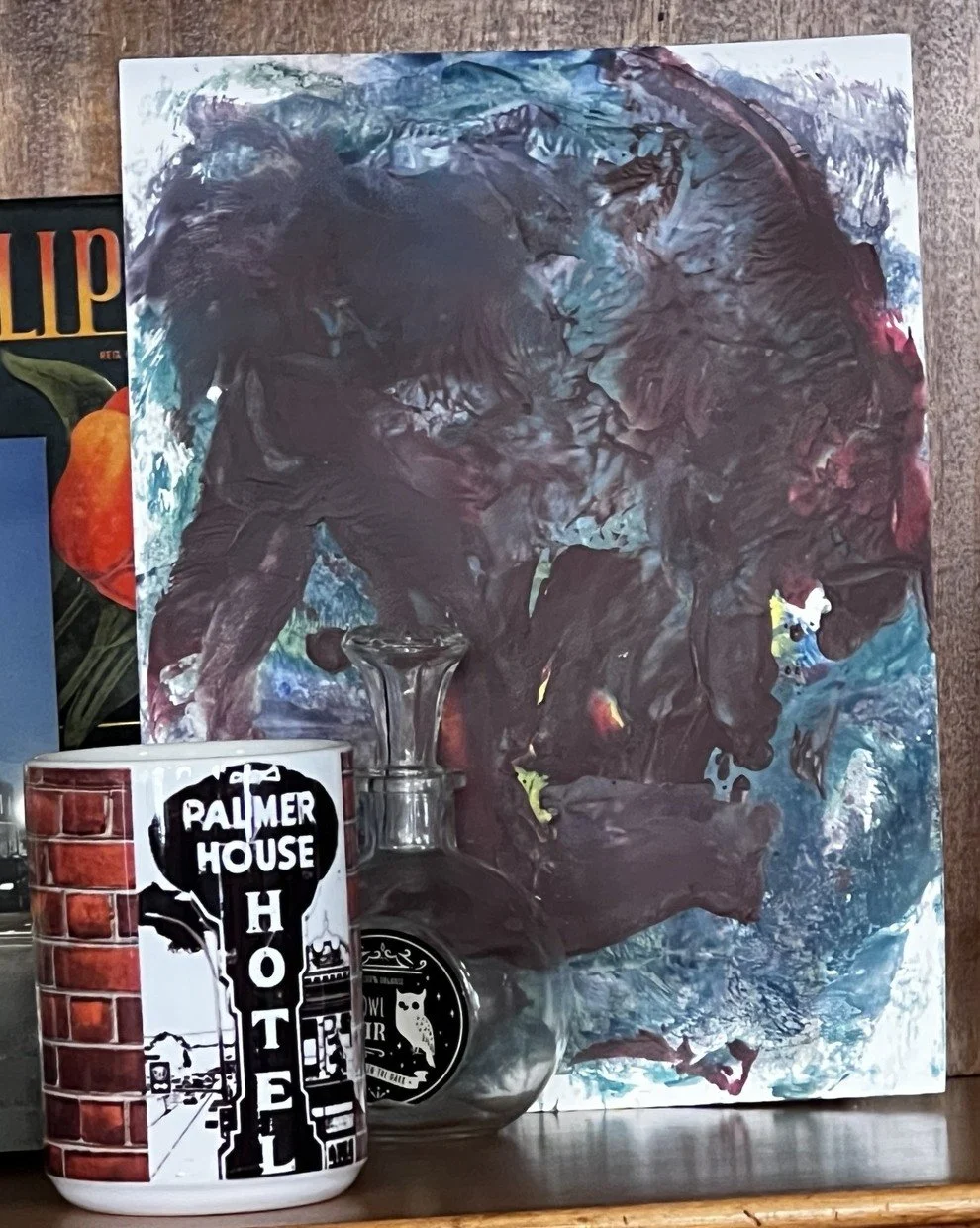 Rage, a spirit artwork with a dark central figure surrounded by teal, blue, white, and magenta, displayed with a Palmer House mug