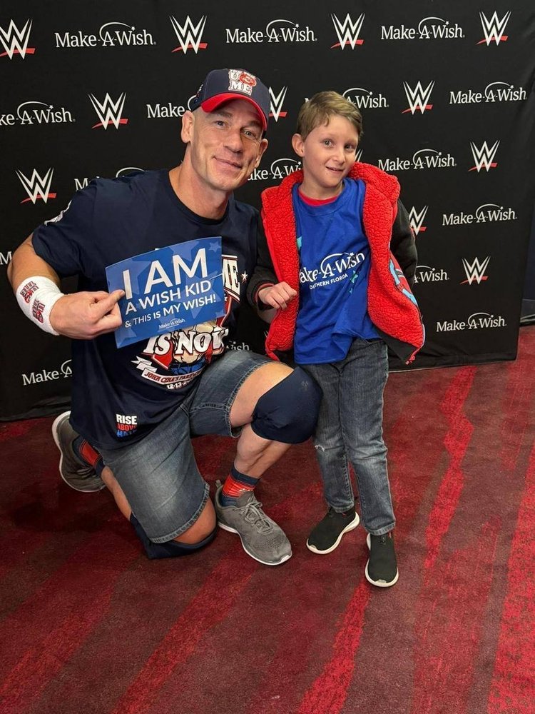 Liam with John Cena holding an I am a wish kid sign