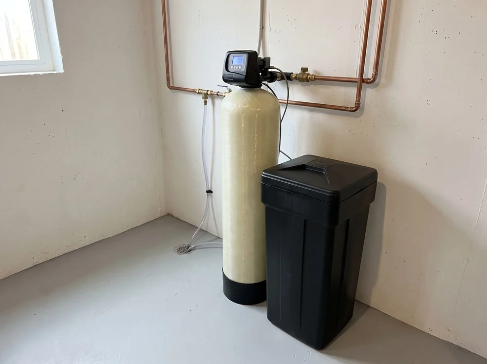 Water softener resin tank and brine tank installed in a basement