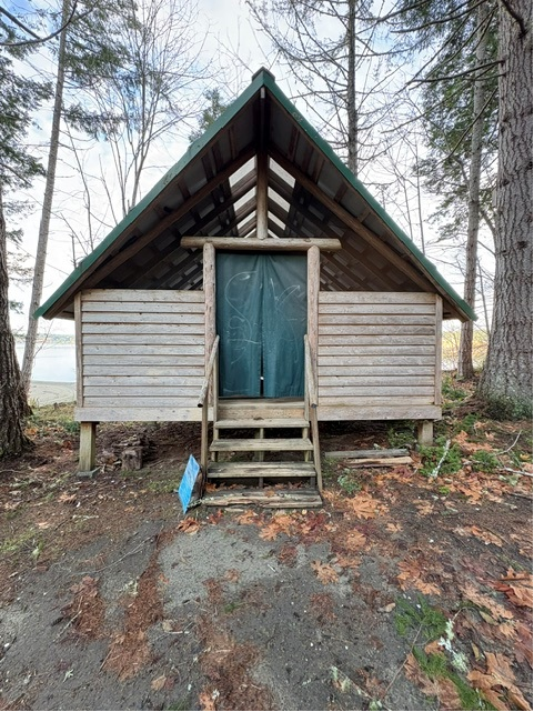 A cabin today, with a canvas door and open gable