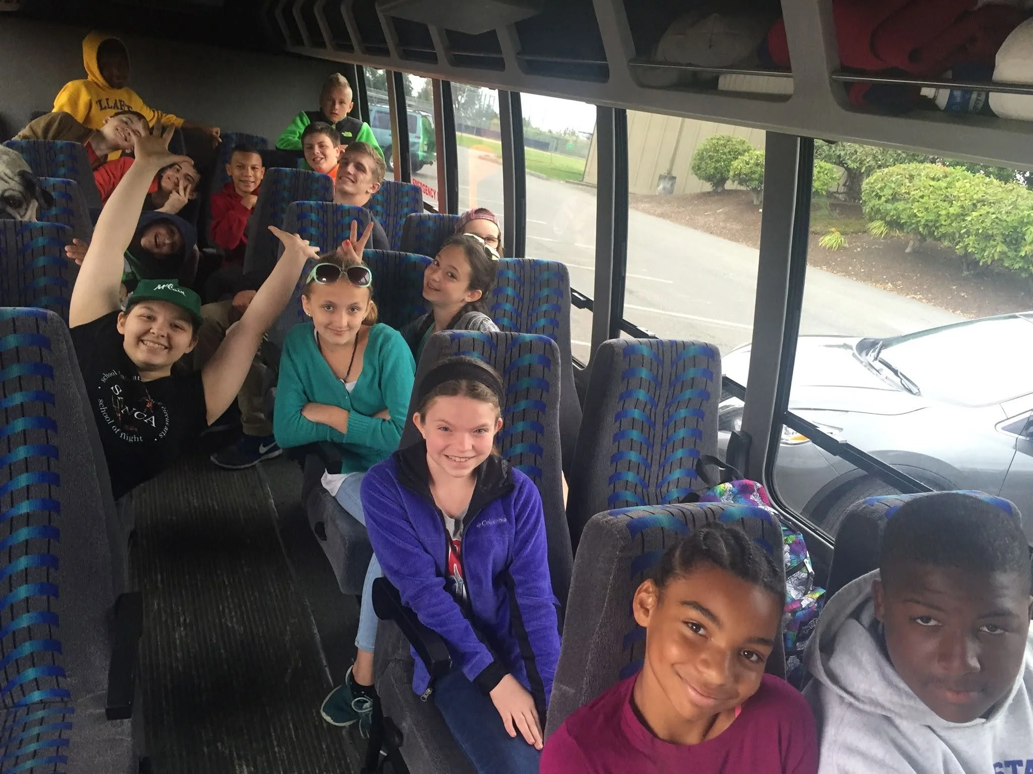The first group of campers on the bus to Camp for Session 1 in 2016, smiling and waving
