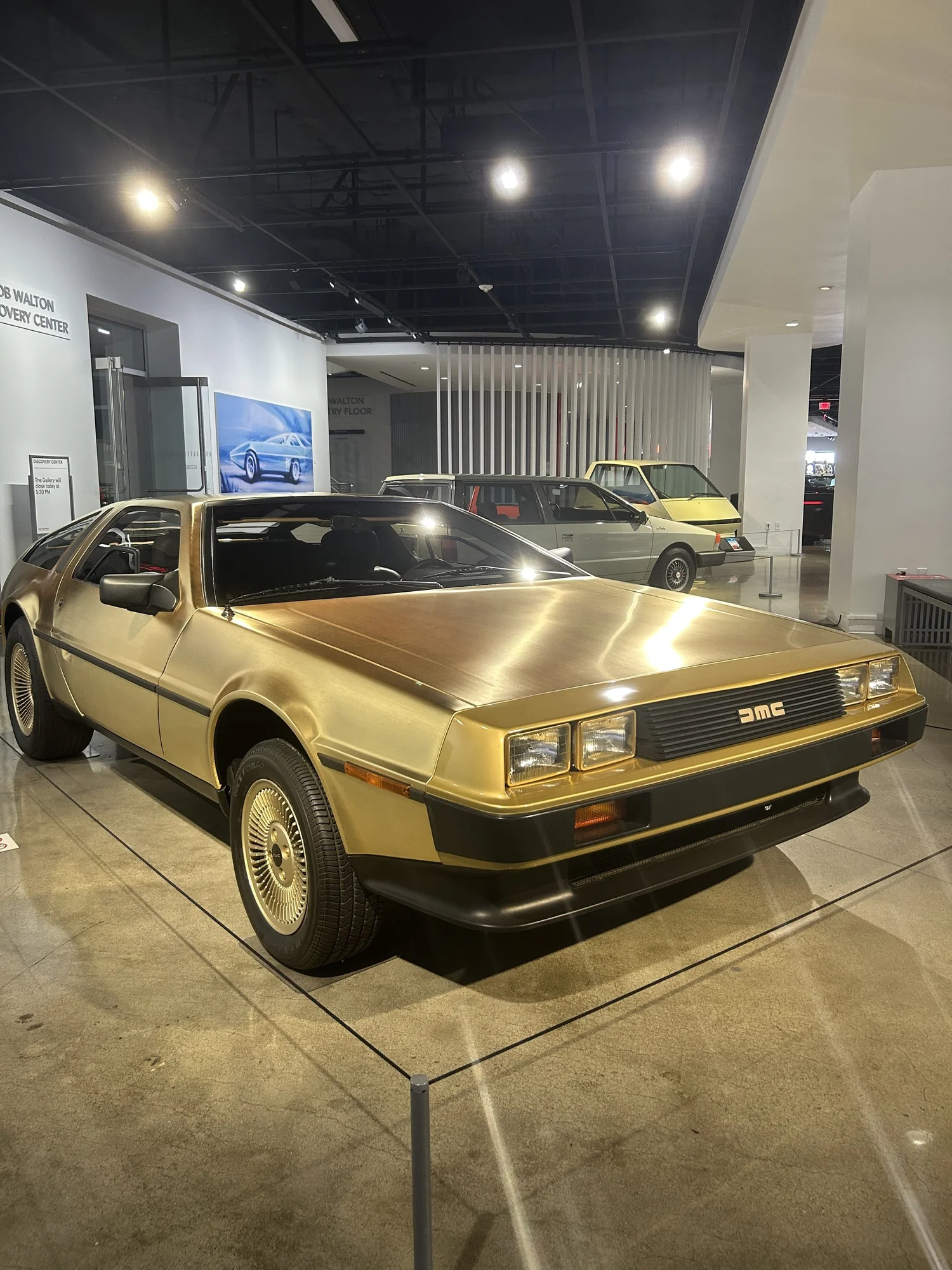 The gold DeLorean under the museum lights