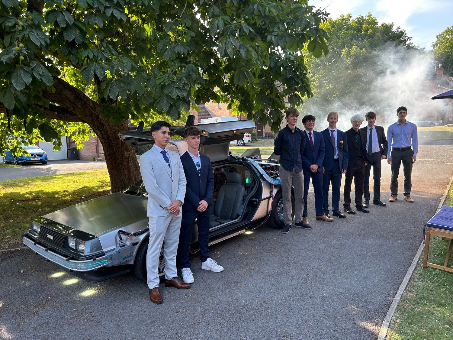 Prom pair in suits beside the time machine