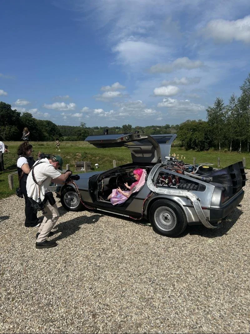 Photographer shooting a bride in the time machine on a sunny wedding day