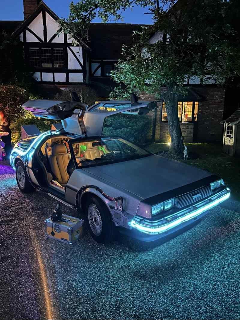 Time machine at dusk with gull-wing doors up and blue underglow