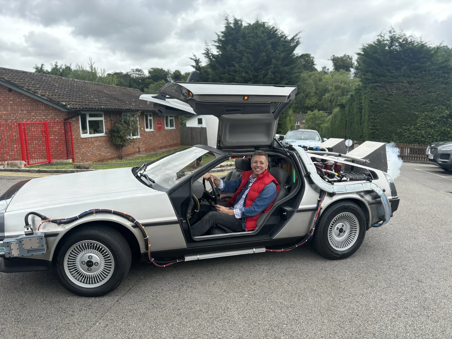 Nick sitting in the classic DeLorean with the gull-wing door up