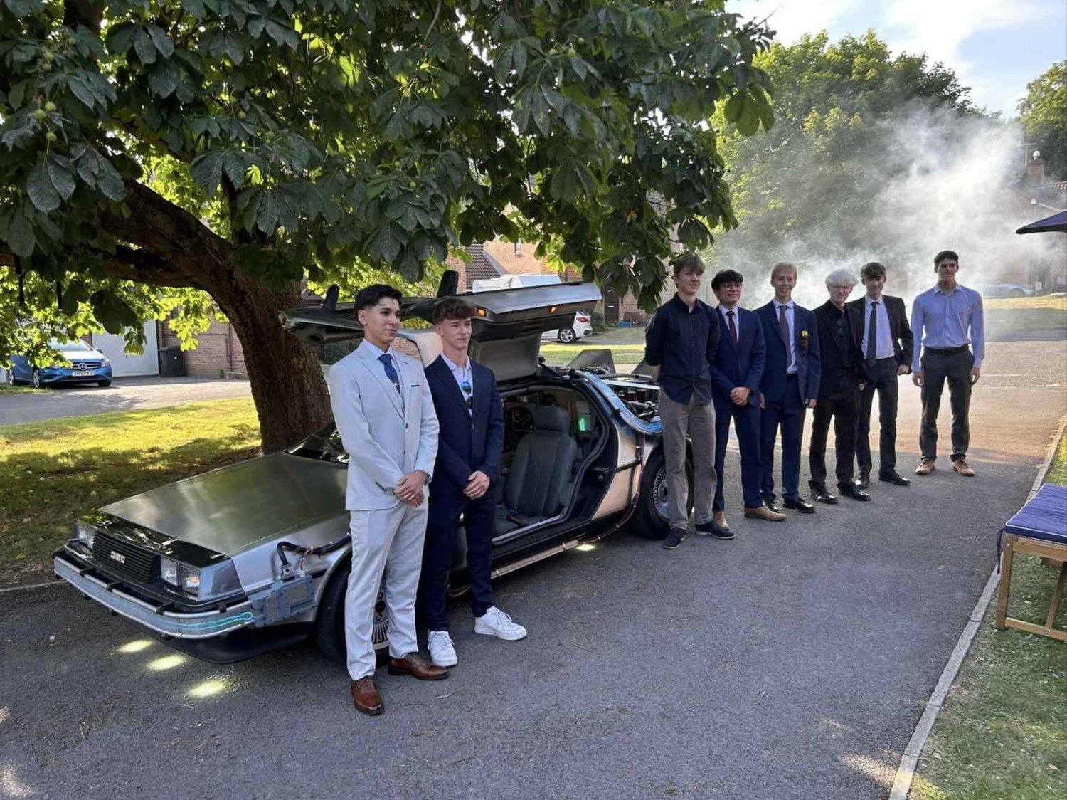 Prom guests in suits beside the time machine