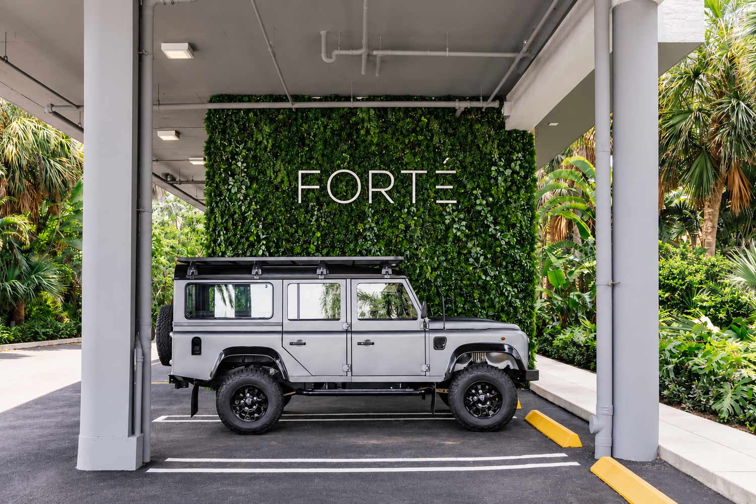 Covered arrival court with a greenwall carrying the building name