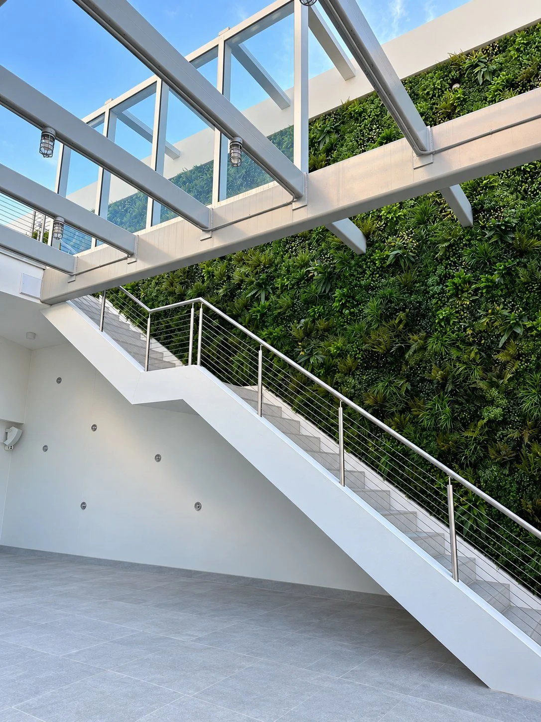 Full-height greenwall beside a white staircase under an open pergola roof in South Beach, FL