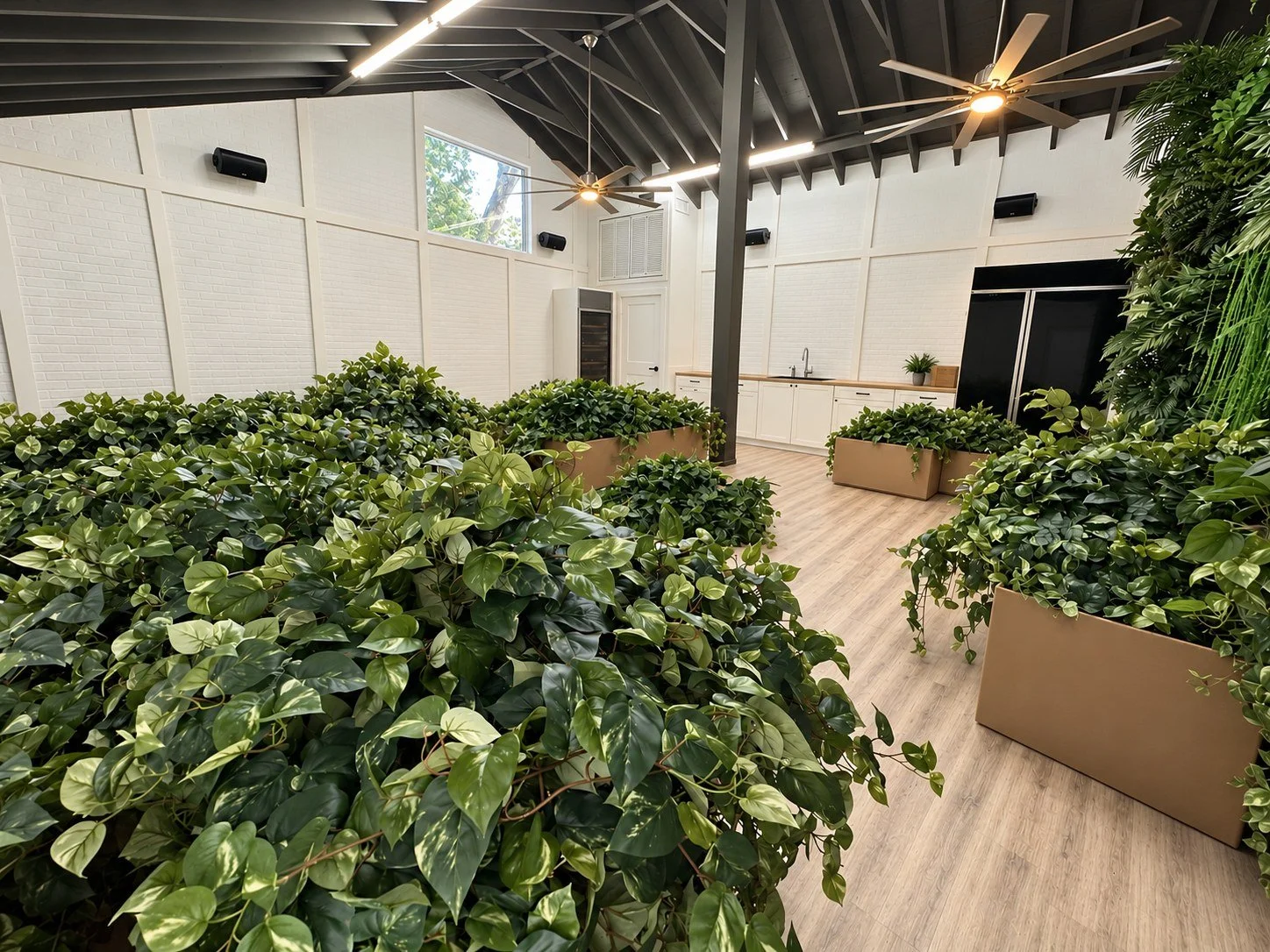 Inside the Lush Artificial Greenwalls studio in Miami, with foliage being composed in planters and a greenwall in progress