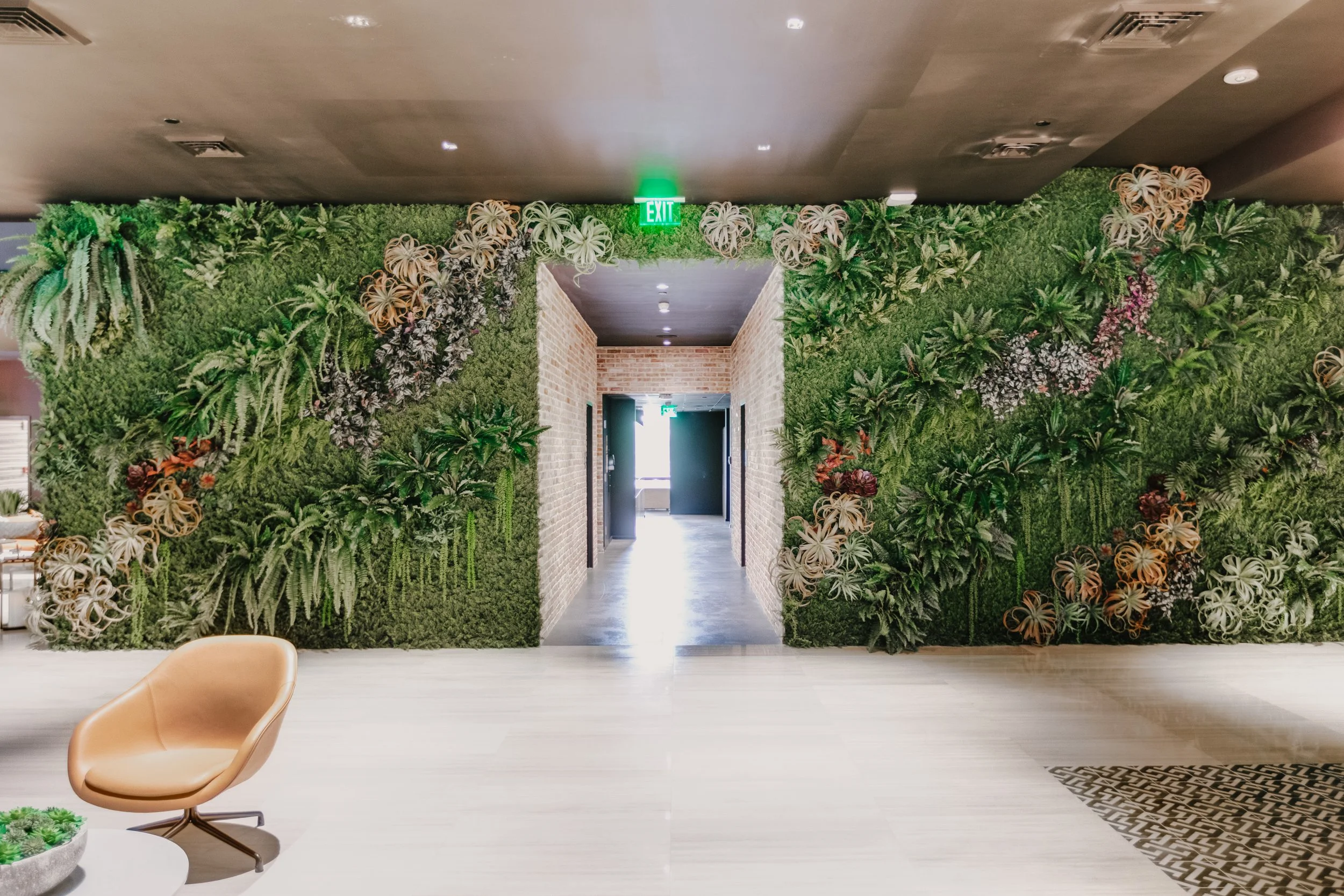 Residential lobby framed by two full-height custom artificial greenwalls