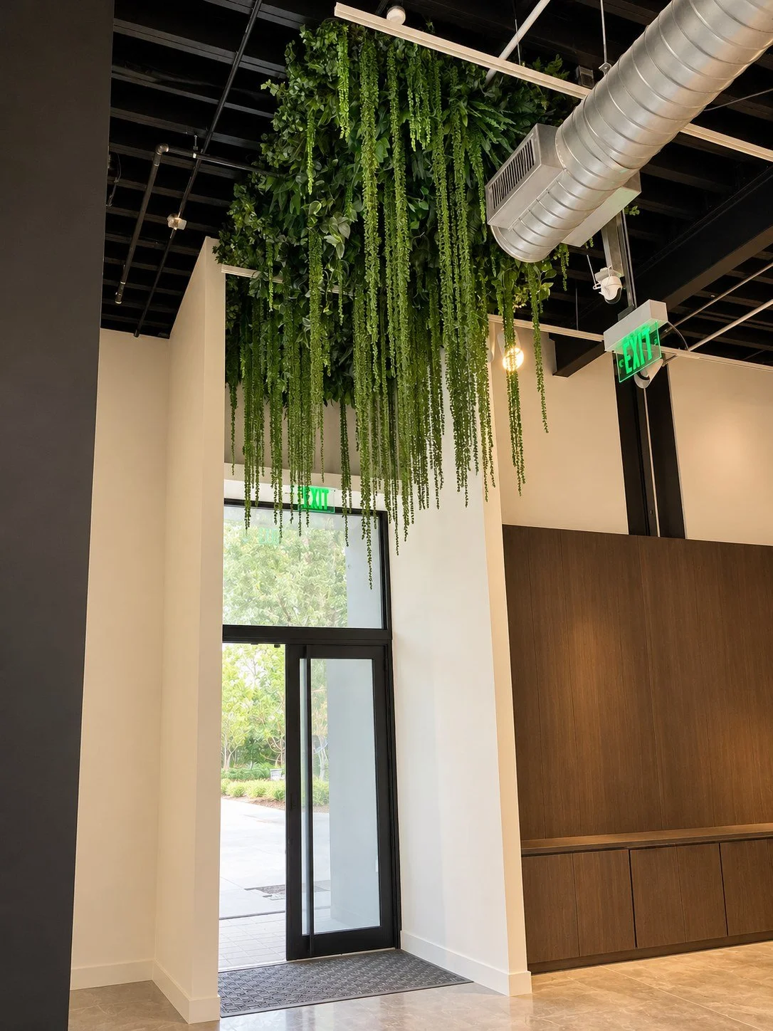 Suspended canopy of trailing artificial foliage above a sales center entrance in Downtown Miami, FL