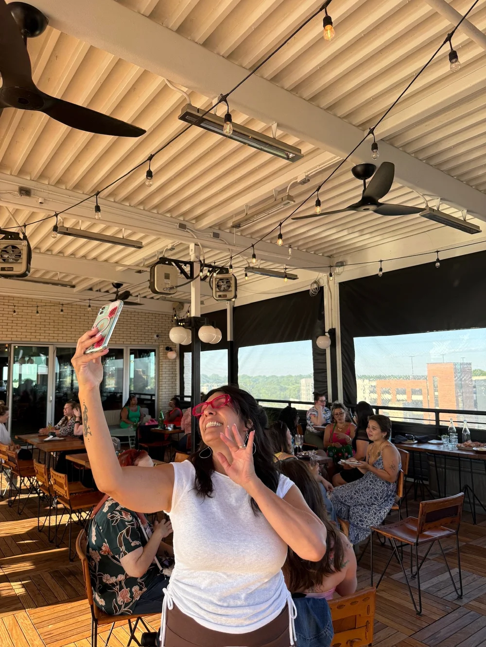 Gina taking a selfie at a rooftop Women's Social
