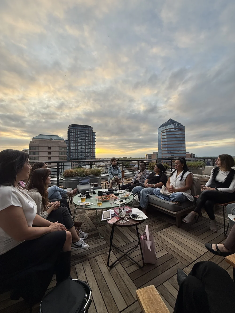 Women in conversation on the rooftop at sunset