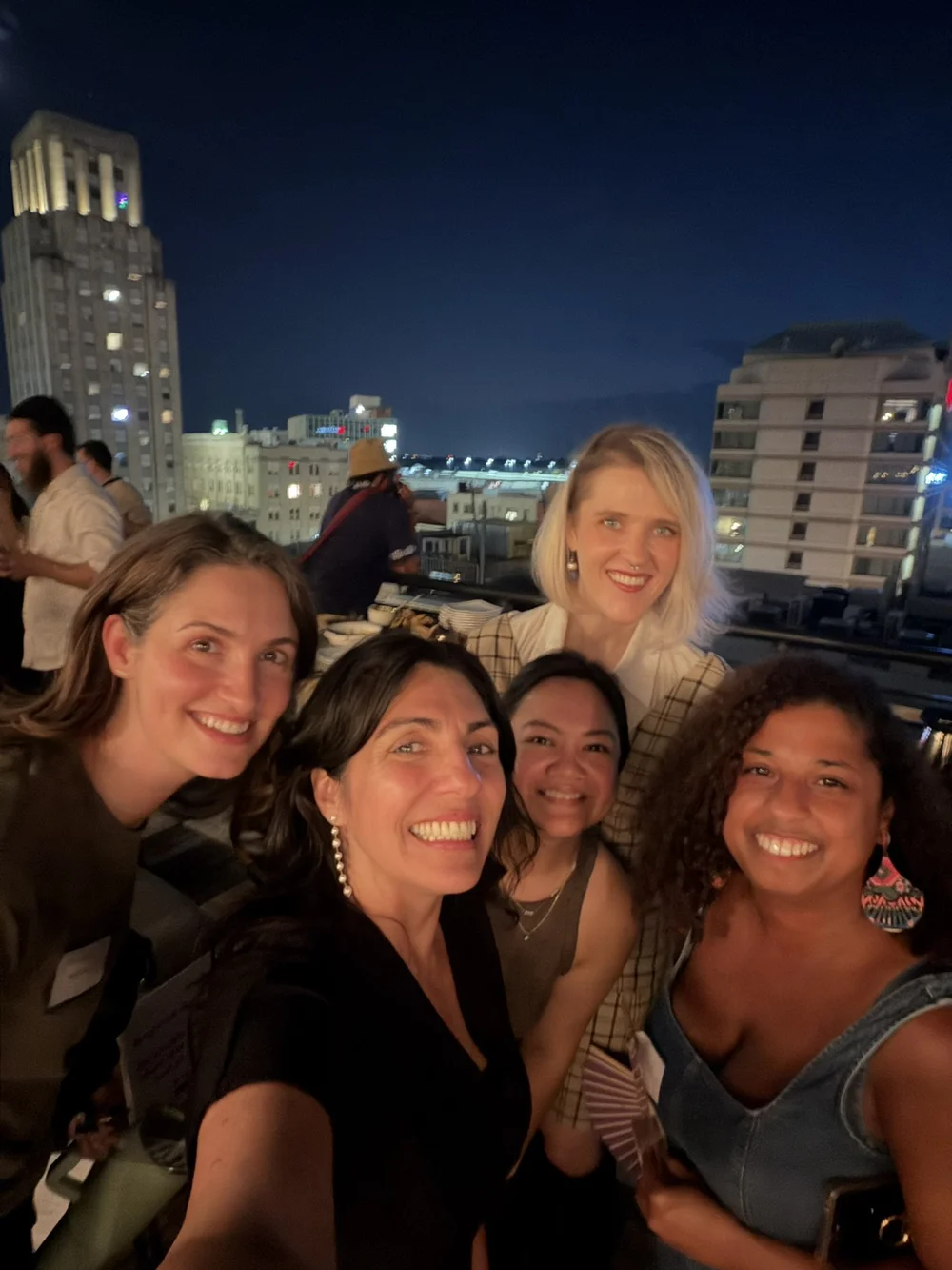 A group selfie on the rooftop at night