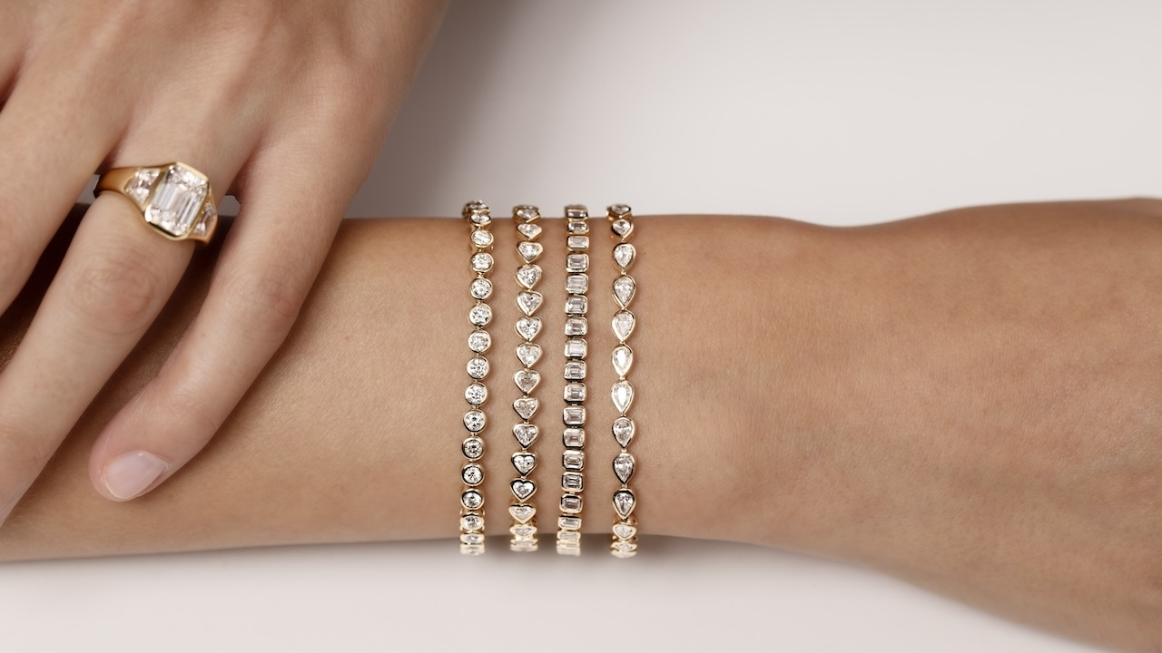 Round, heart, emerald-cut and pear-shaped diamond bracelets worn with a gold diamond ring