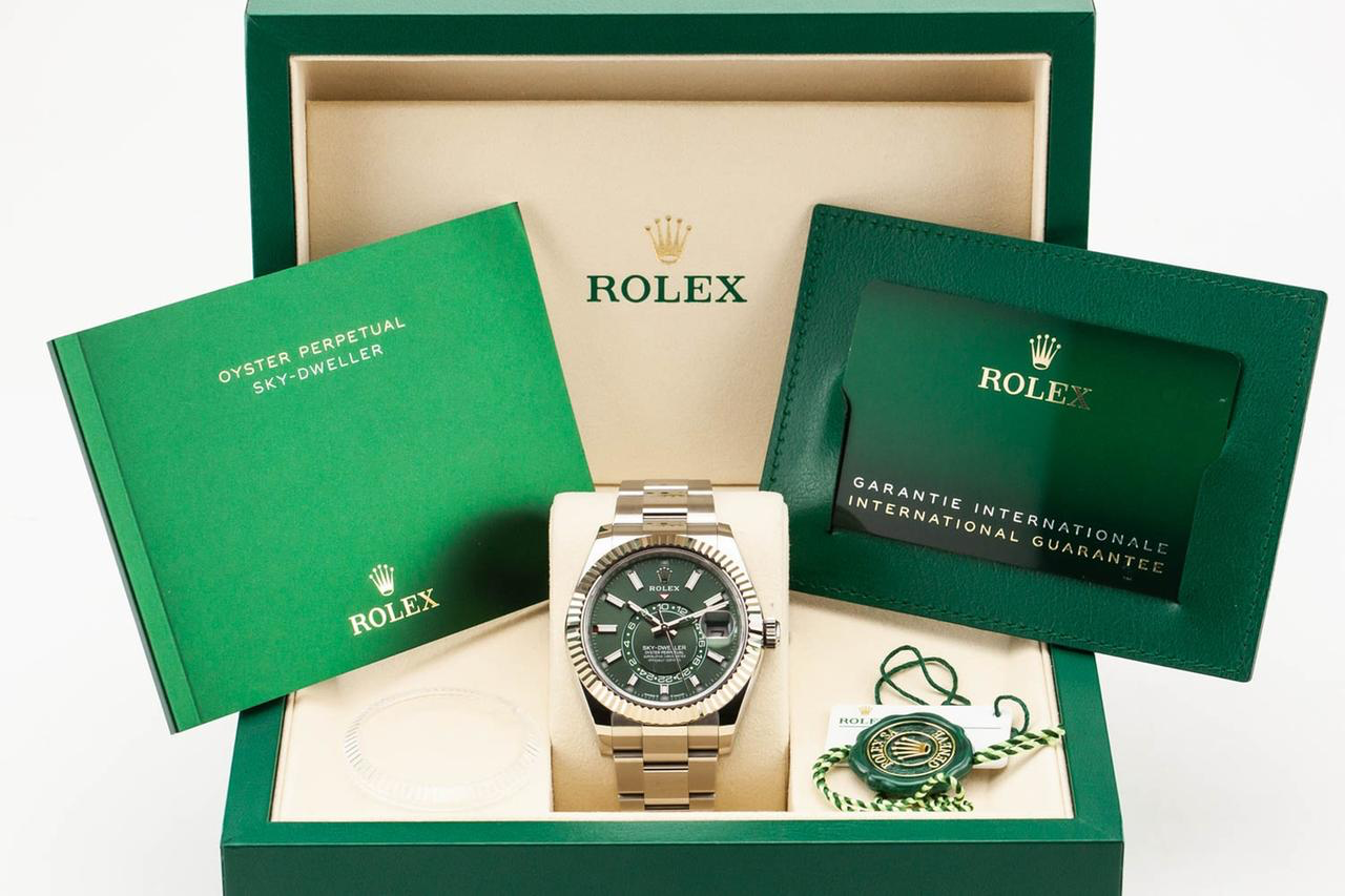 Yellow gold Rolex Sky-Dweller with a green dial in its presentation box with papers