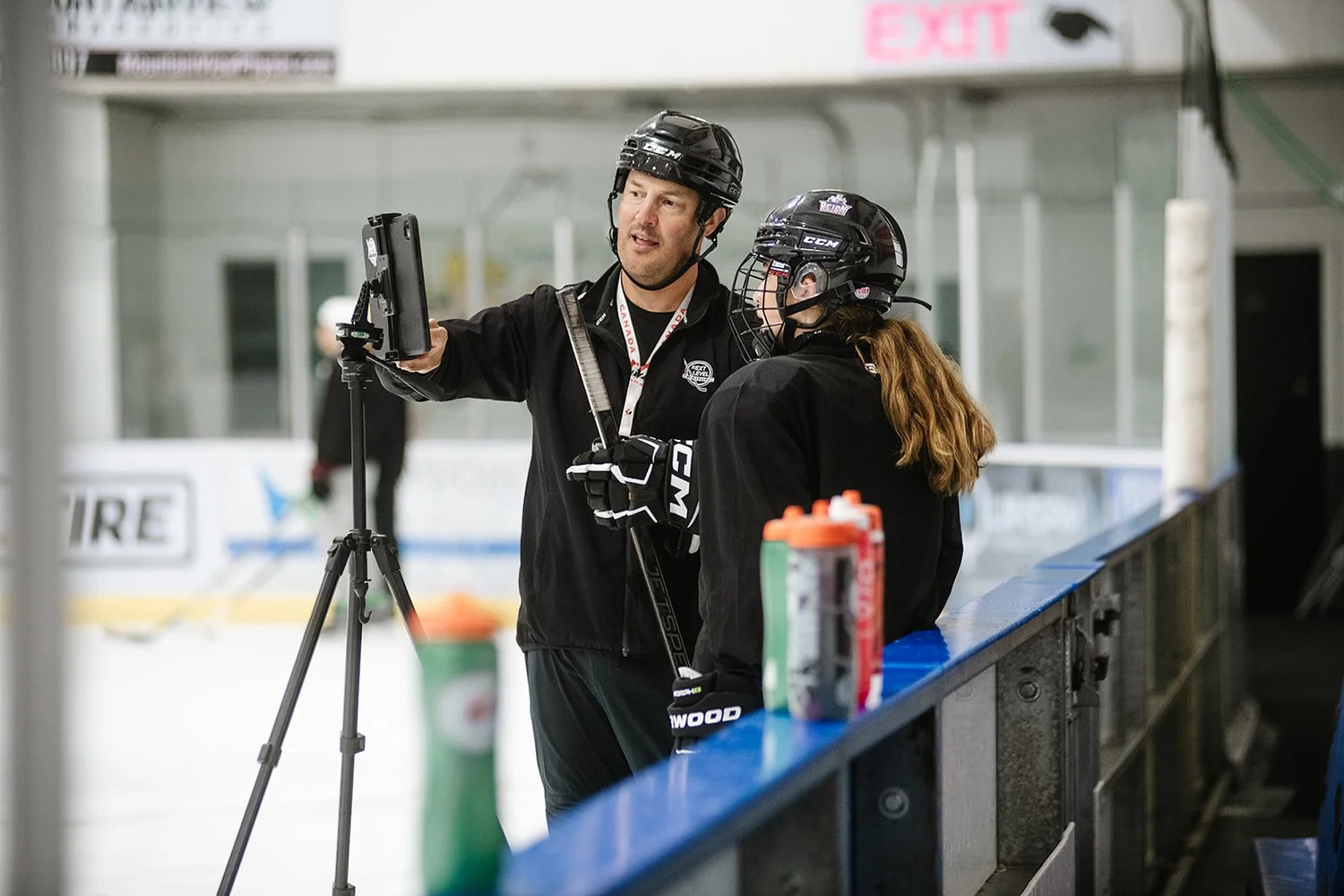 Bryce reviewing video with a player at the boards
