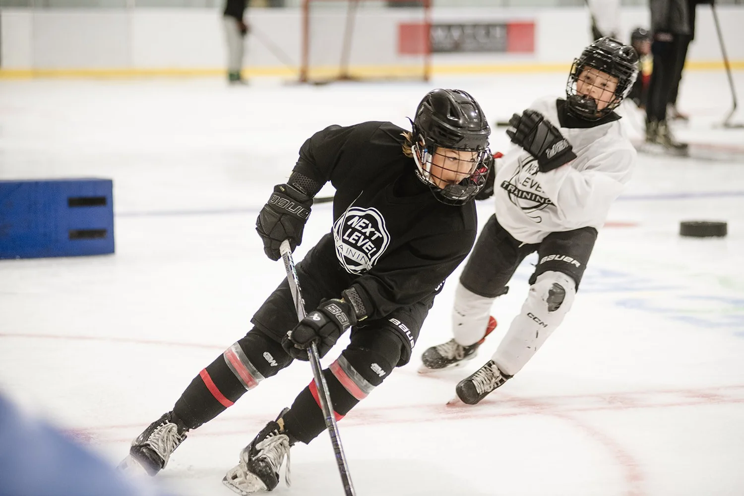 Players battling for the puck at a Next Level summer camp